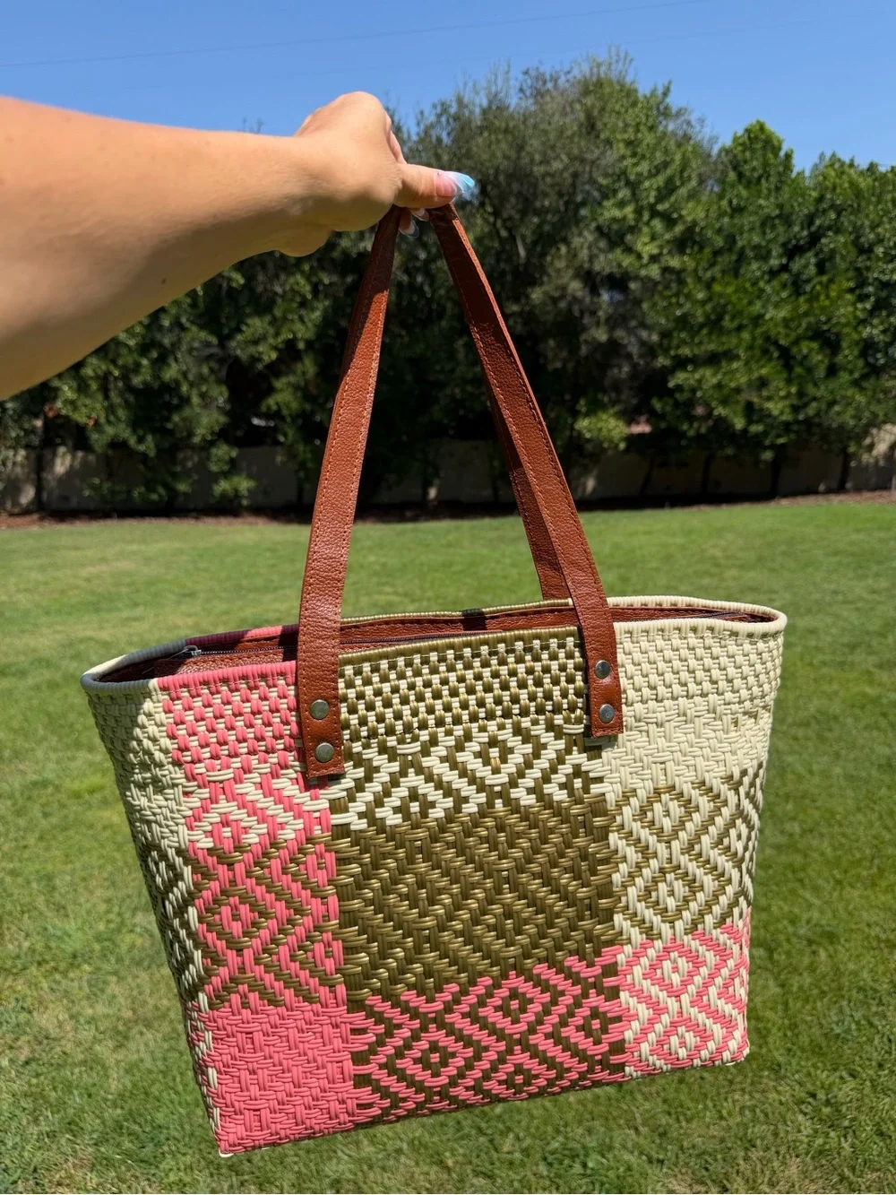 Woven Straw Tote Bag with Brown Leather Handles and Pink Tassel Accent
